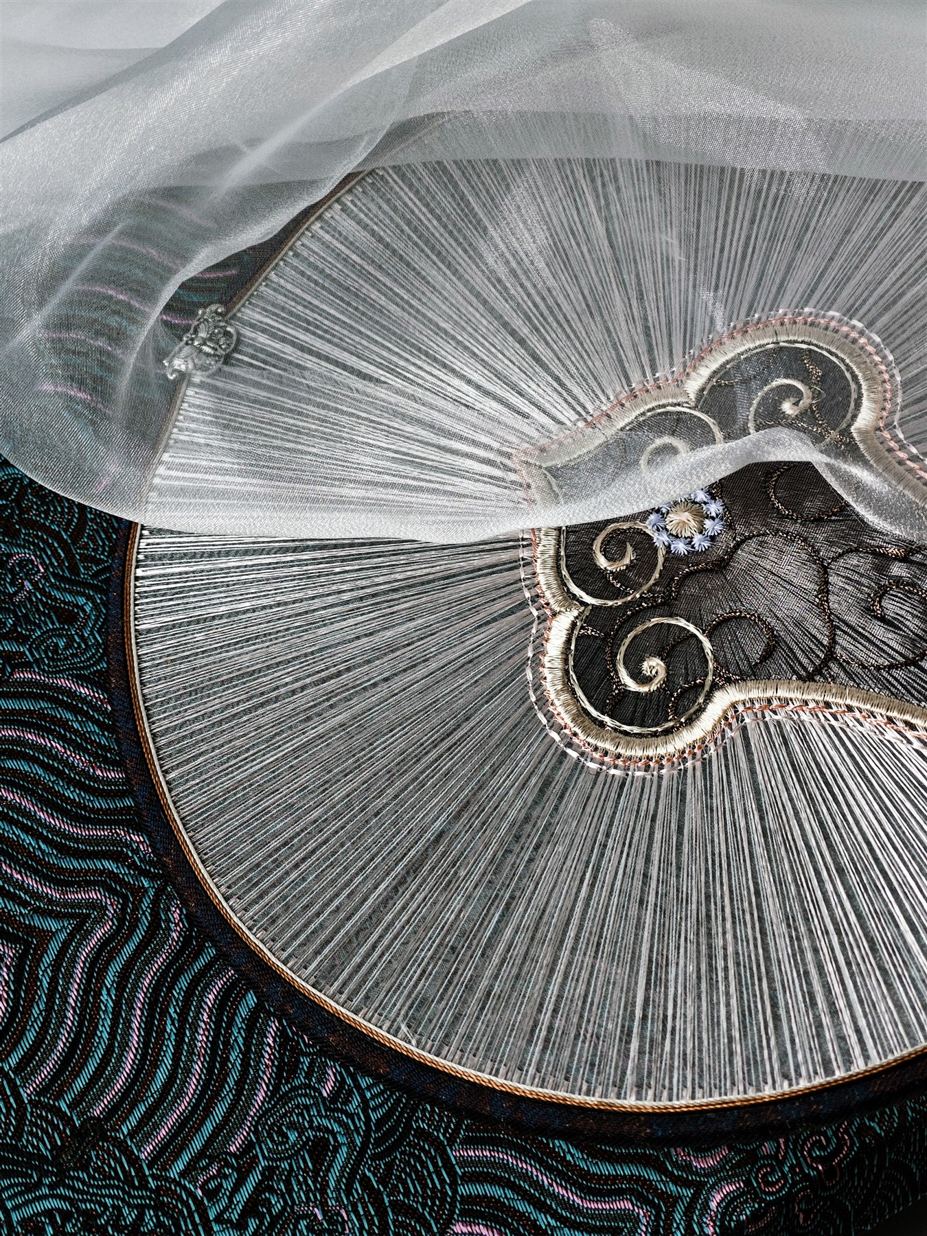 Translucent embroidery product revealing fine radial silk threadwork