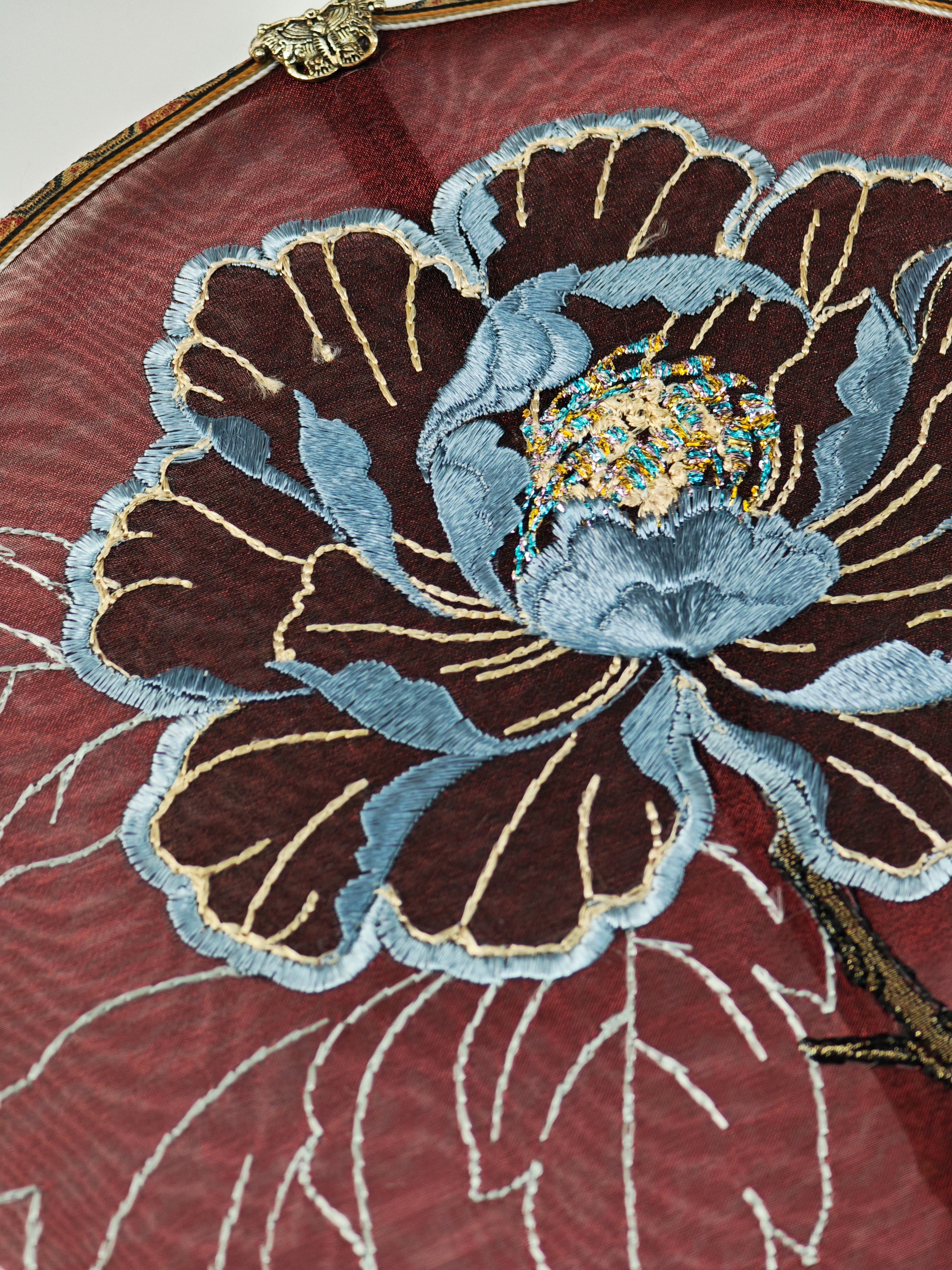 Close-up of pale blue and deep brown peony embroidery threads